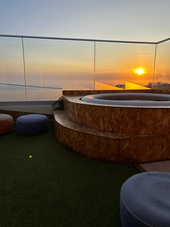 a hot tub on the roof of a building with the sunset at Casas Jeronimos in Lourinhã