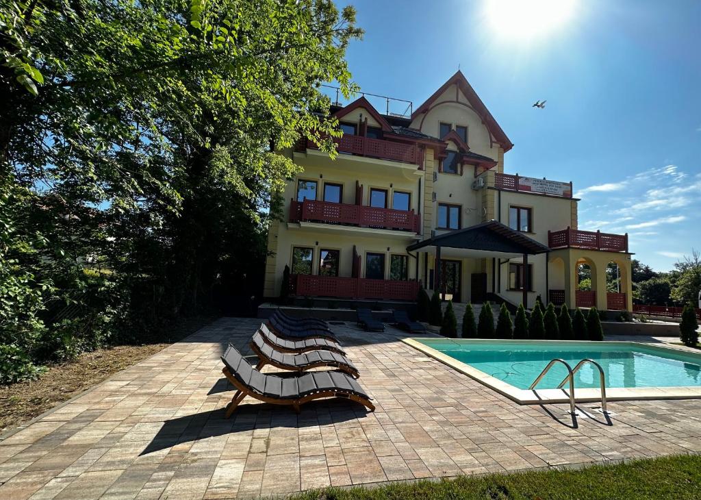 ein Haus mit einem Pool vor einem Haus in der Unterkunft Apartman Katarina in Palić