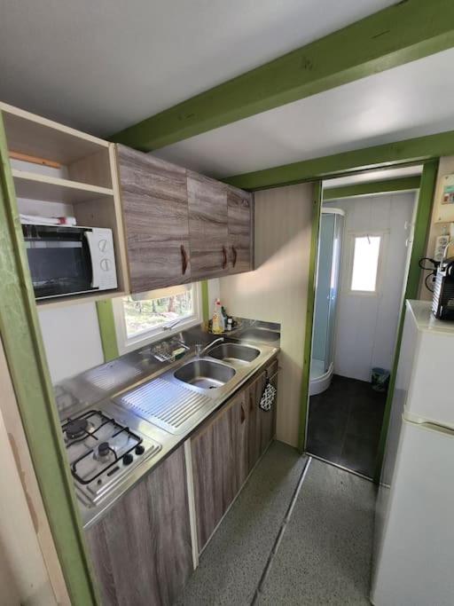 a small kitchen with a sink and a microwave at Chalet in Petreto-Bicchisano