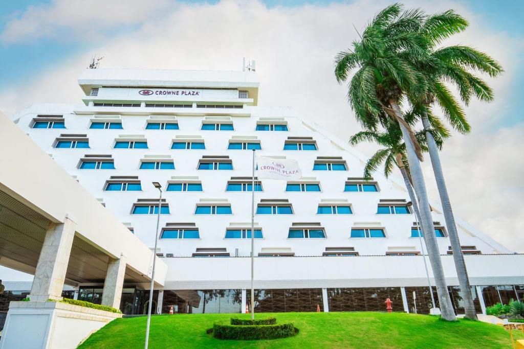 a hotel with palm trees in front of it at Crowne Plaza Managua, an IHG Hotel in Managua