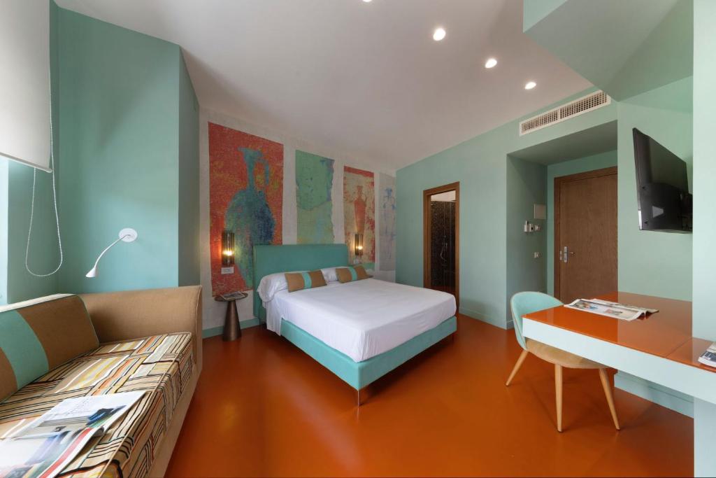 1 dormitorio con cama, sofá y escritorio en Sorrento Rooms Deluxe en Sorrento