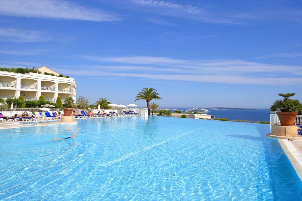 uma pessoa a nadar numa grande piscina num resort em EXCEPTIONNEL sur CANNES vue mer piscine em Cannes