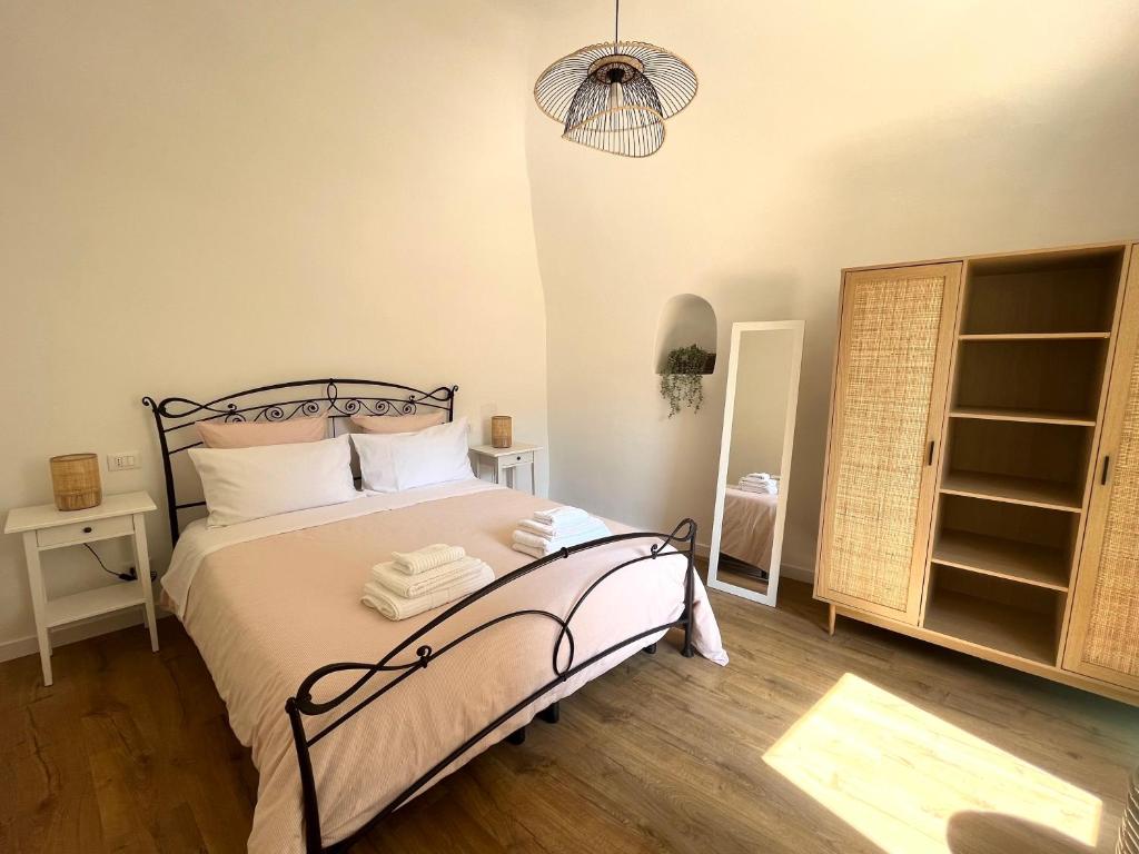 ドルチェアックアにあるDa I Ciarui casa vacanzeのベッドルーム1室(白いシーツとランプ付)