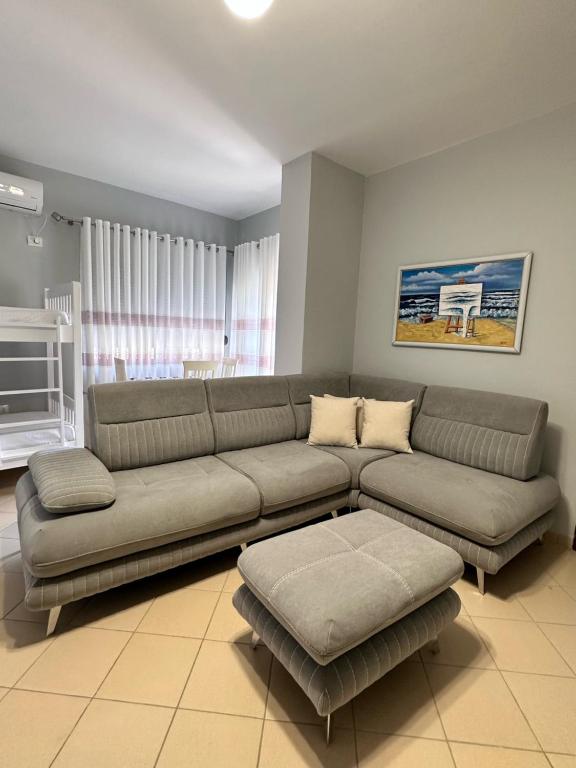 uma sala de estar com um sofá grande e uma mesa em Solei Apartments em Saranda