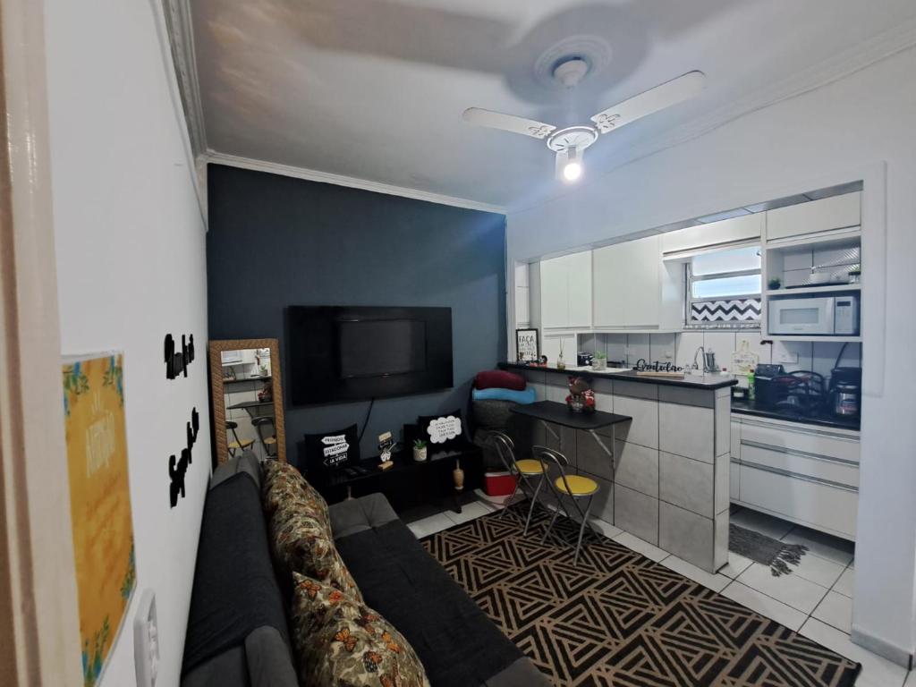 a living room with a couch and a kitchen at Apto Top Boqueirão Praia Grande. in Praia Grande