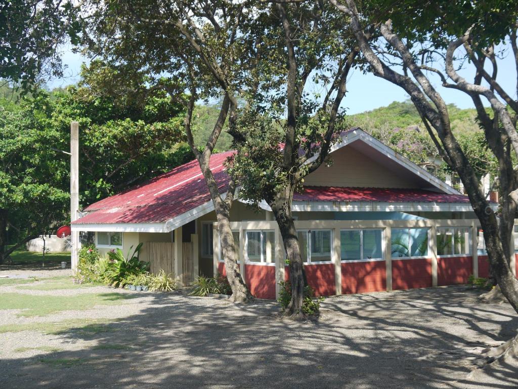 a building with a red roof and some trees at Casita A in Pagudpud