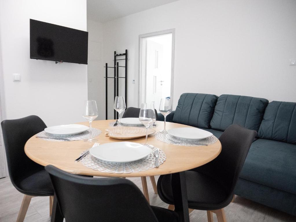 a dining room table with chairs and a blue couch at Apartamenty MARINA Puck in Puck