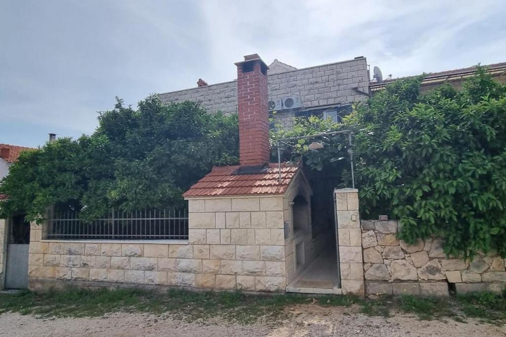 un edificio de ladrillo con chimenea en la pared en Apartments and rooms with parking space Supetar, Brac - 5658, en Supetar