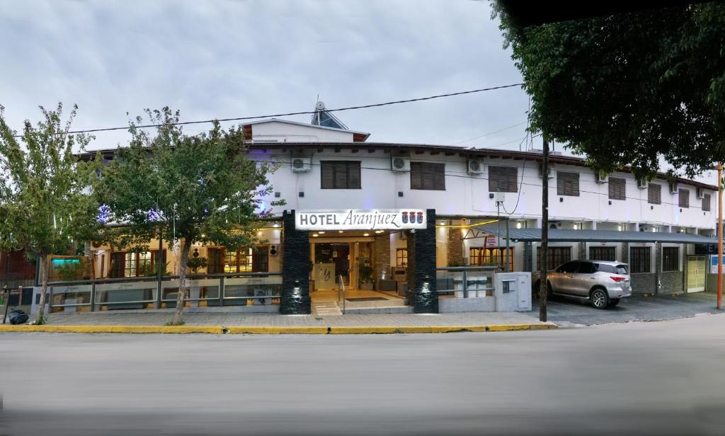 a large white building with a car parked in front of it at Aranjuez Real in Villa Carlos Paz