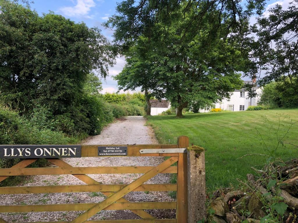una puerta a una entrada con un signo de nosotros abierto en ella en Llys Onnen - North Wales Holiday Cottage, en Mold