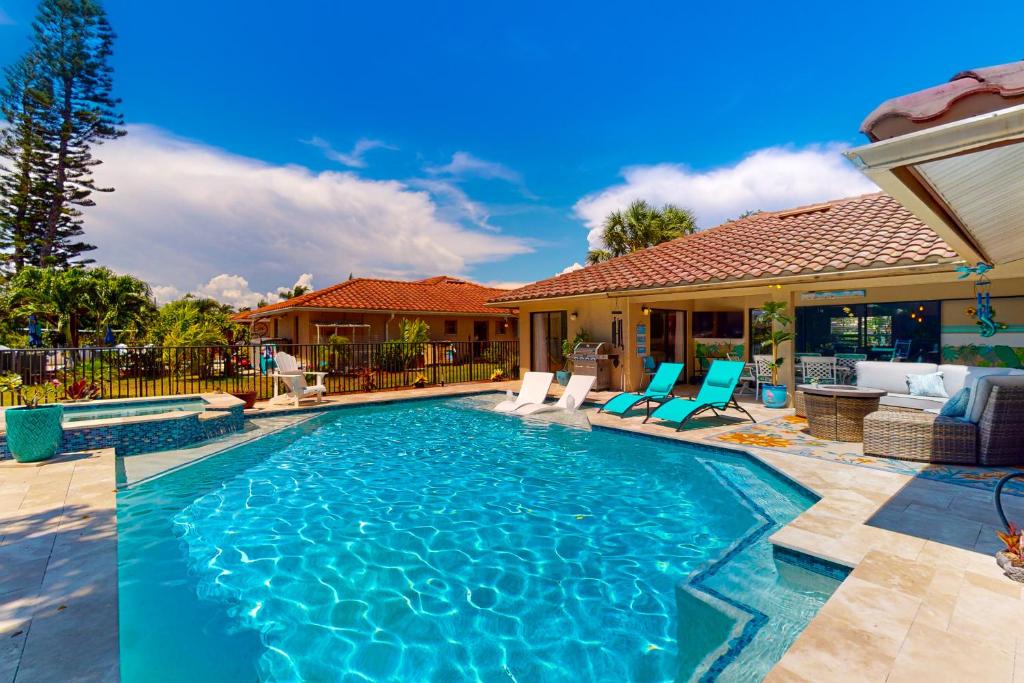ein Swimmingpool mit Stühlen und ein Haus in der Unterkunft Blue Sunset in Bonita Springs