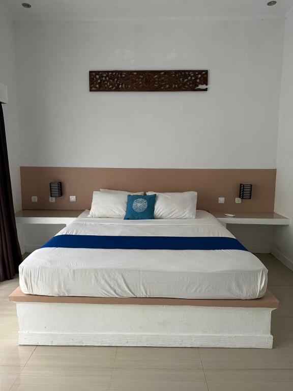 a bed with a blue pillow on top of it at Santai Retreat in Kuta Lombok