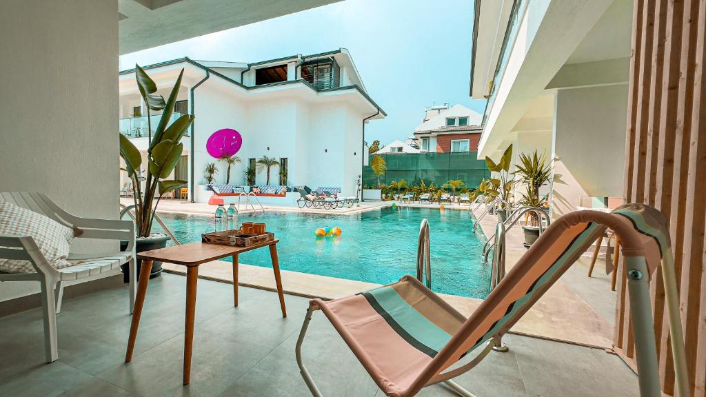 a swimming pool with a chair and a table at S-Cape Hotel Fethiye in Fethiye