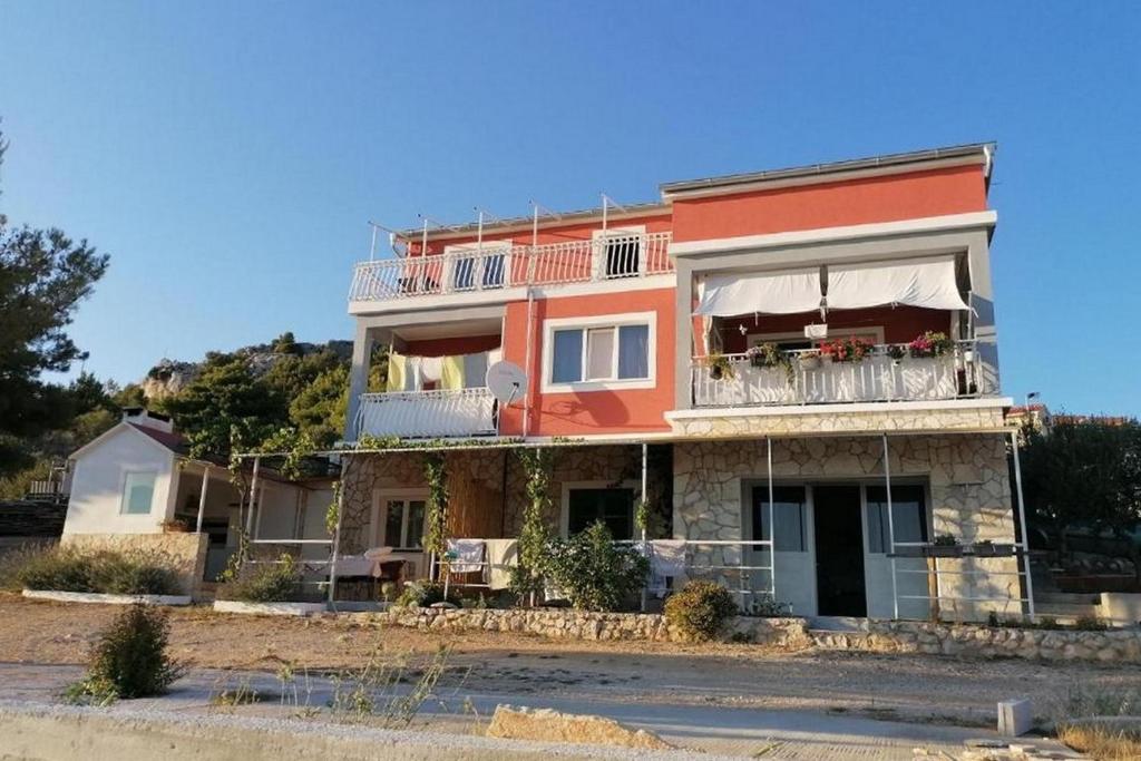 a large orange building with a balcony at Apartments with parking space Zaboric, Sibenik - 21367 in Zaboric