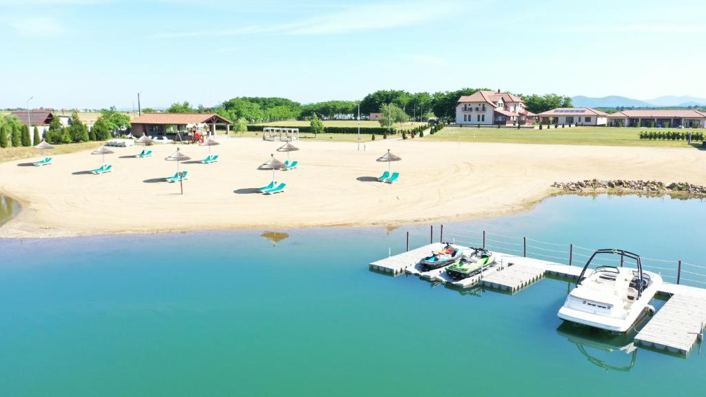 - une plage avec des chaises longues et des bateaux dans l'eau dans l'établissement Pensiunea Brise, à Medieşu Aurit