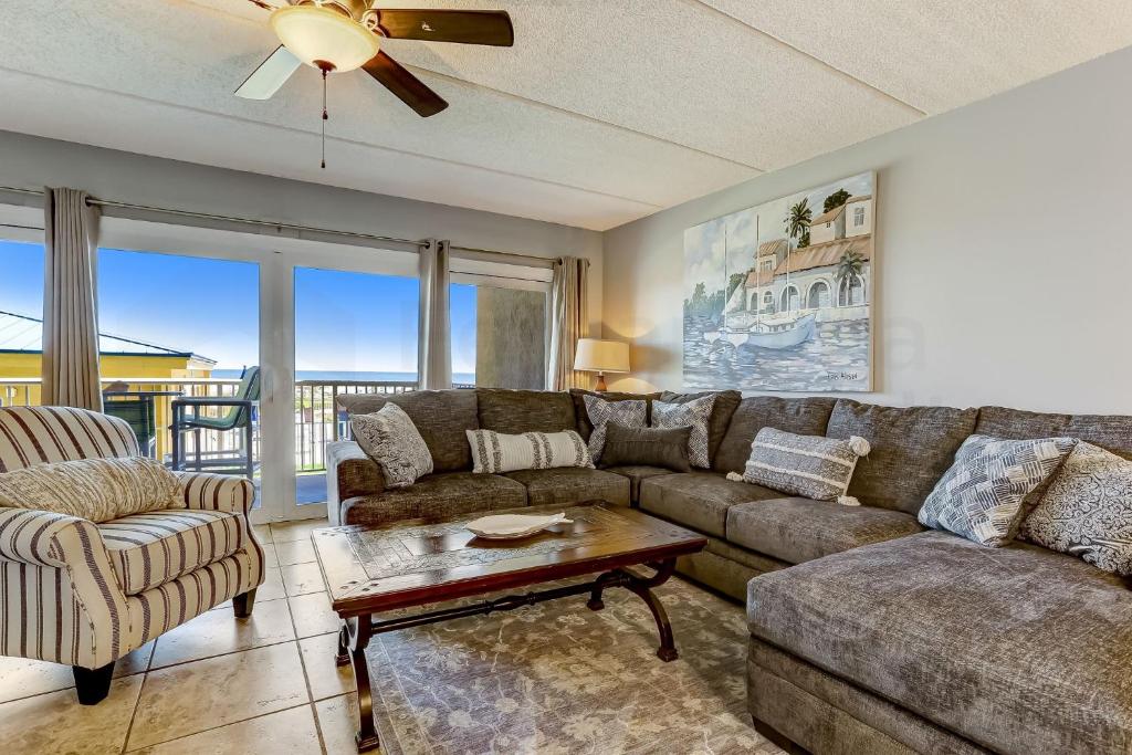 a living room with a couch and a table at Steps to Oceanside Condo in Amelia Island