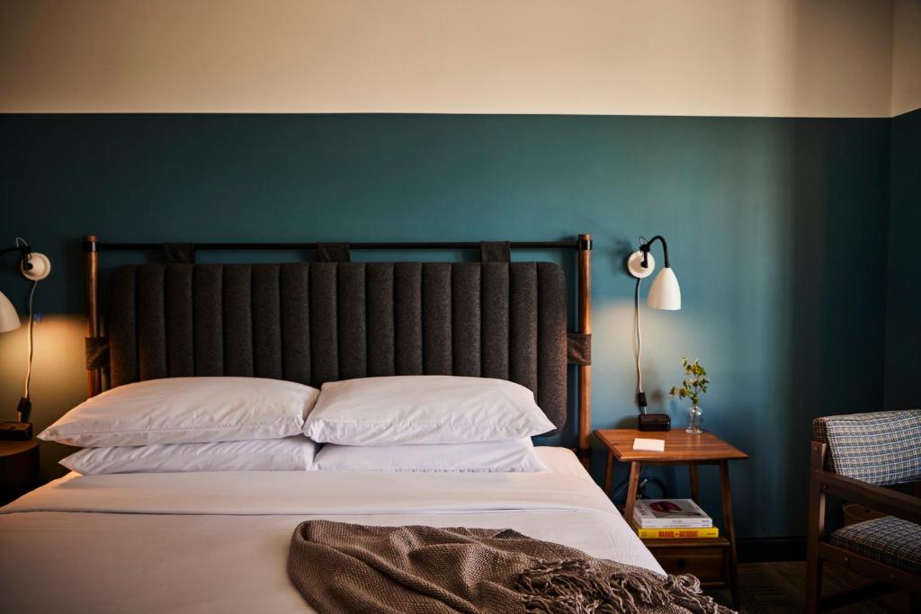 a bedroom with a large bed with a blue wall at The Junto in Columbus