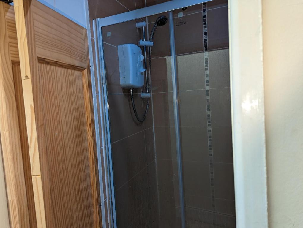 a shower in a bathroom with a glass door at oldham town centre double room 5 in Oldham