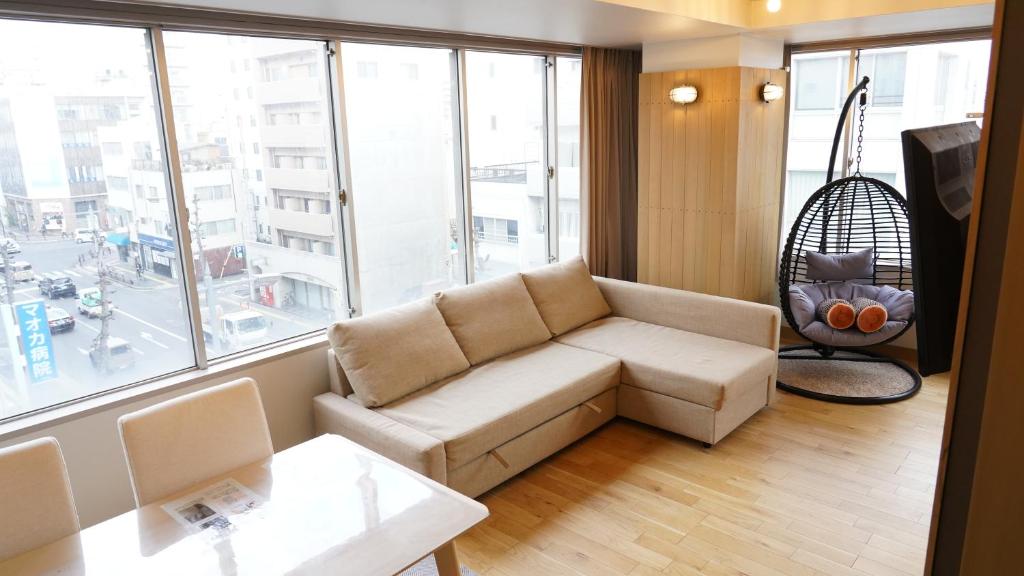 a living room with a couch and a large window at Hotel Yuzuki in Takamatsu