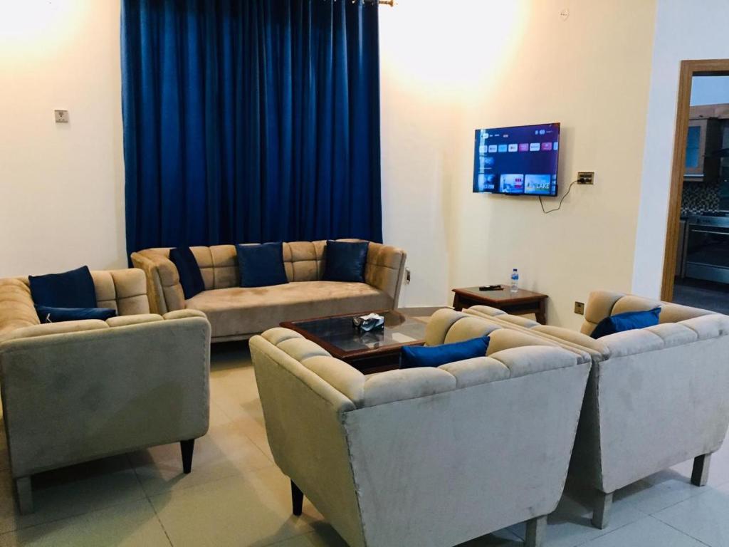 a living room with two couches and a tv at Islamabad Residency 2 in Islamabad