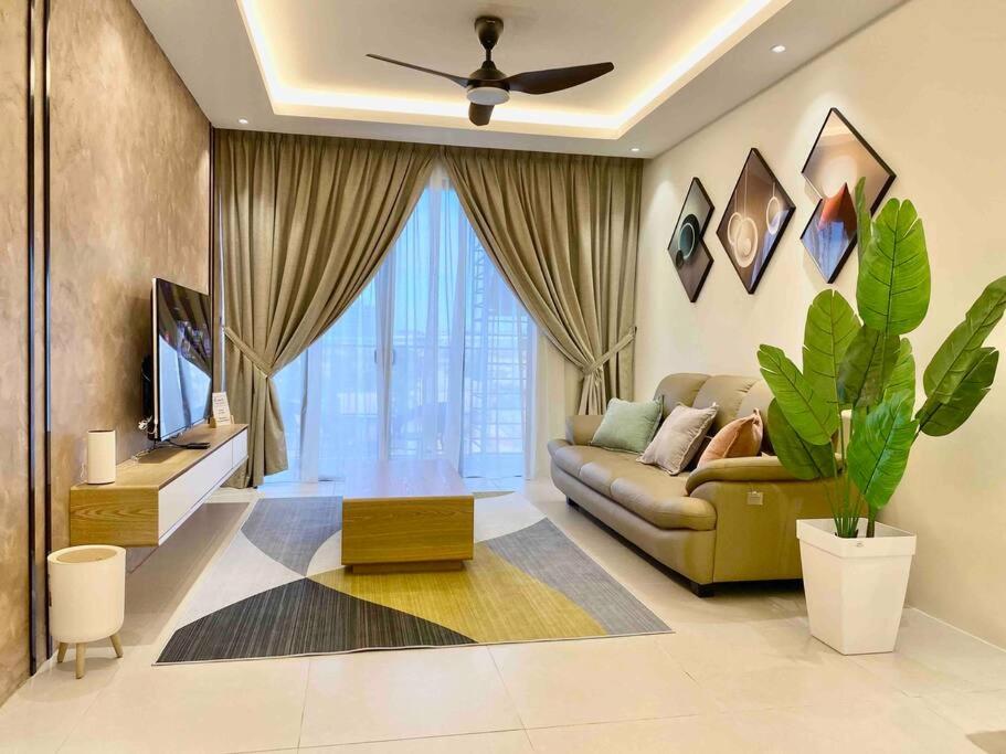 a living room with a couch and a tv at Armadale Residence 3R3B Gala City Airport in Kuching