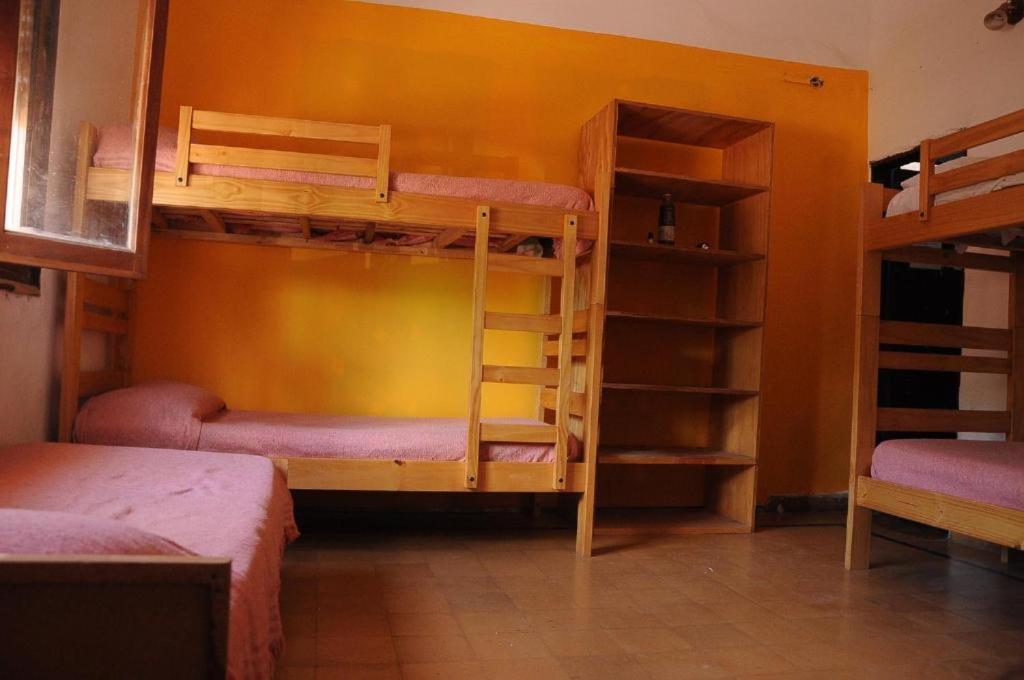聖馬科斯塞拉利昂的住宿－Jaracanda Hostel San Marcos，带两张双层床的客房和带架子的房间