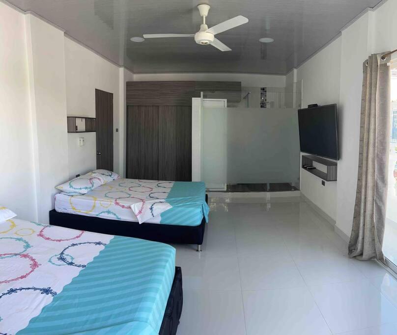 a bedroom with two beds and a flat screen tv at cabaña la bonita in Doradal