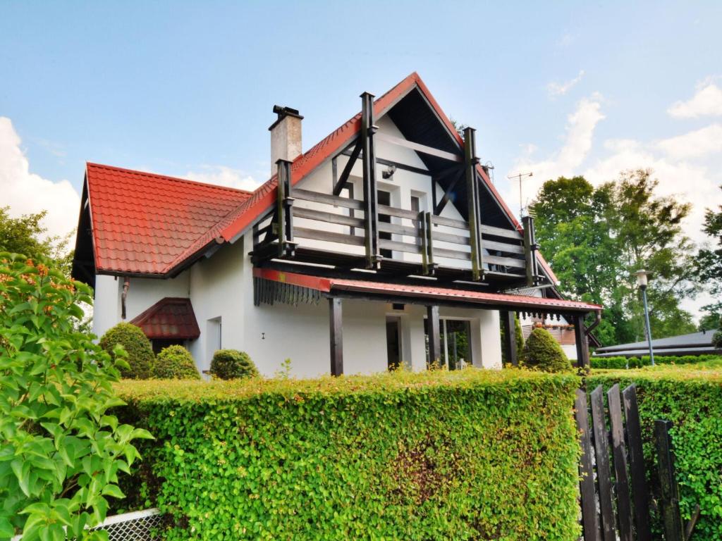 dom z czerwonym dachem na krzewie w obiekcie Holiday house by the lake, Charzykowy w Charzykowach