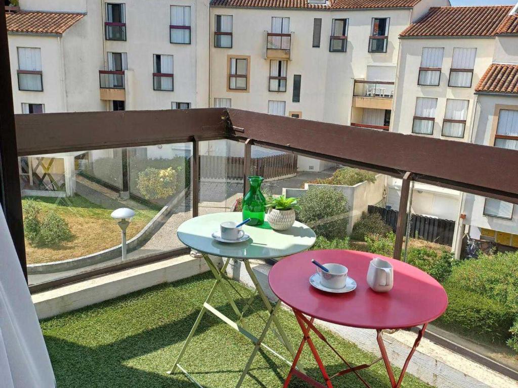 une table et des chaises sur un balcon avec vue sur un immeuble dans l'établissement Charmant T3 avec piscine, proche plage - Port des Minimes, La Rochelle - FR-1-551-69, à La Rochelle