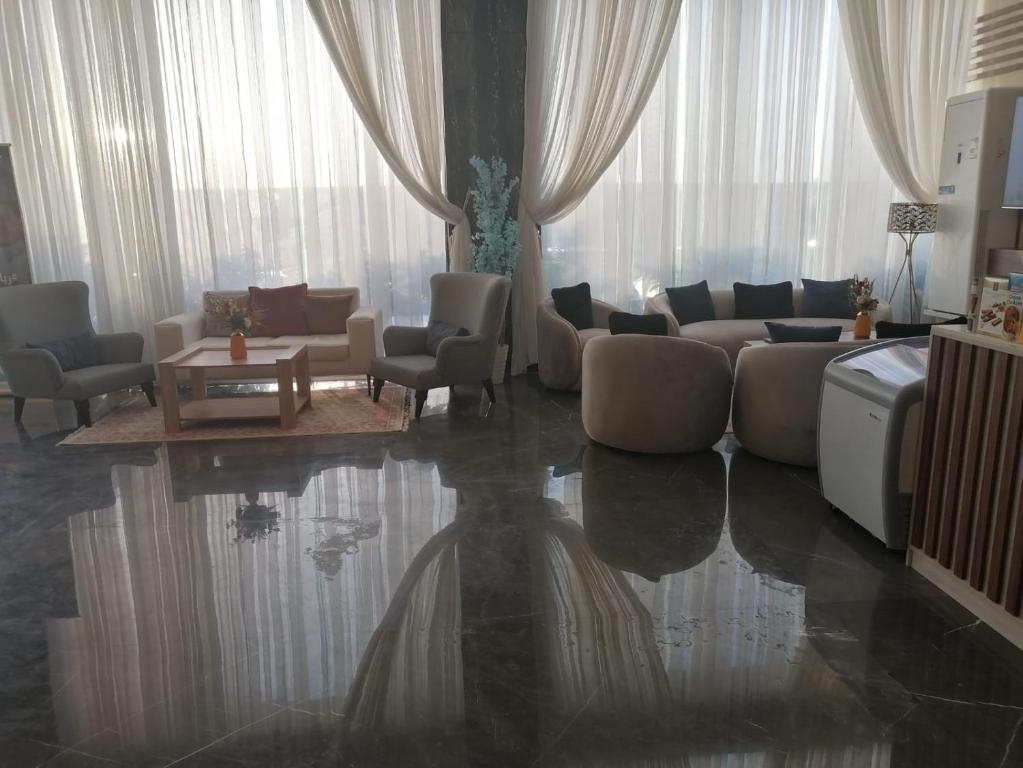 a living room with a couch and chairs and a table at شهرزاد للأجنحة الفندقية in Abū Qa‘ar