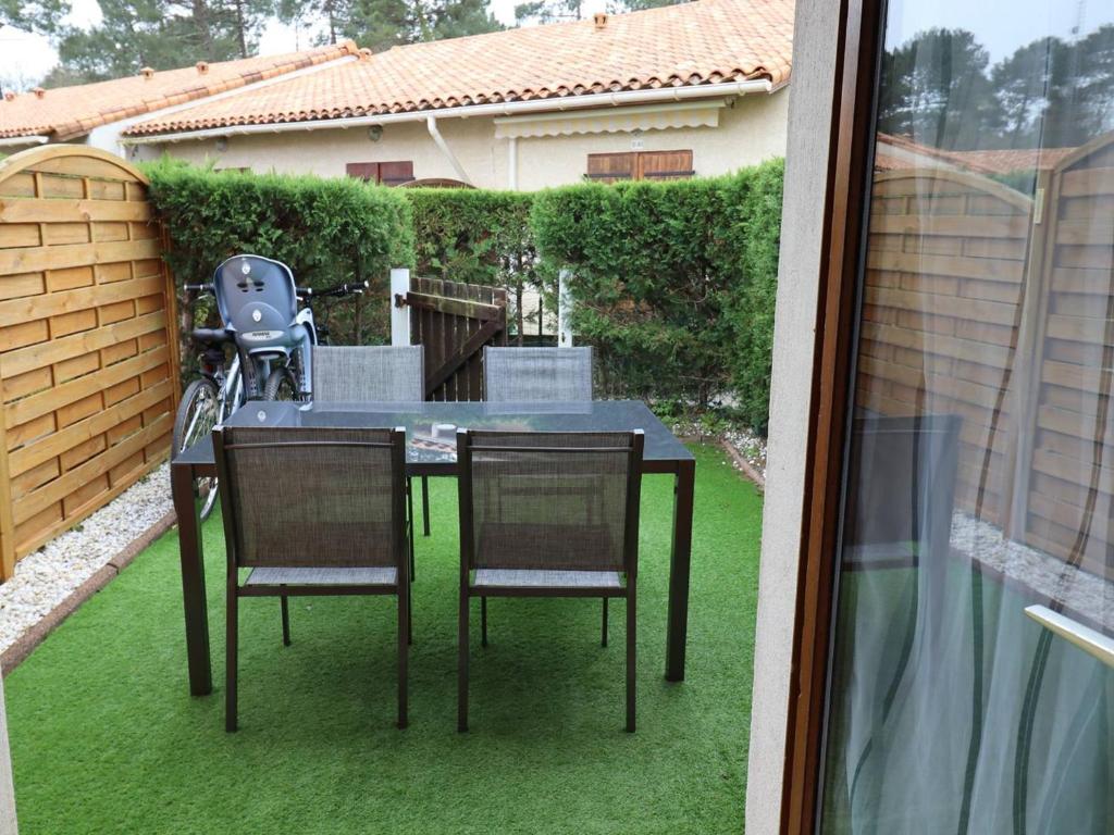 eine Terrasse mit einem Tisch und Stühlen auf dem Rasen in der Unterkunft Maison Les Mathes, 1 pièce, 4 personnes - FR-1-738-7 in Les Mathes