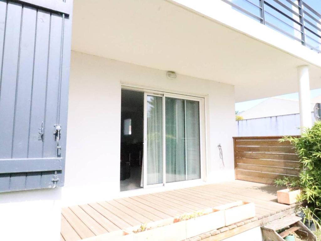 ein weißes Haus mit einer Veranda und einer Glasschiebetür in der Unterkunft Appartement Meschers-sur-Gironde, 3 pièces, 4 personnes - FR-1-738-1 in Meschers-sur-Gironde