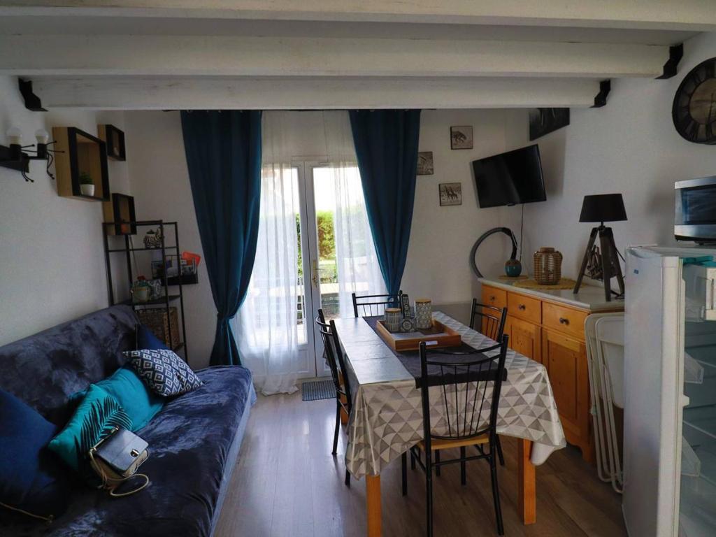 un salon avec un canapé et une table dans l'établissement Maison 4 pers. avec piscine, tennis, et parking - Proche La Palmyre - FR-1-738-20, aux Mathes