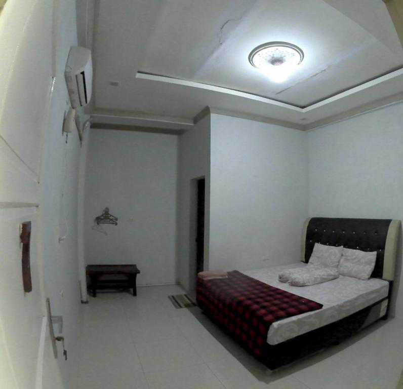 a bedroom with a bed in a room at FURQAN GUEST HOUSE in Iboih