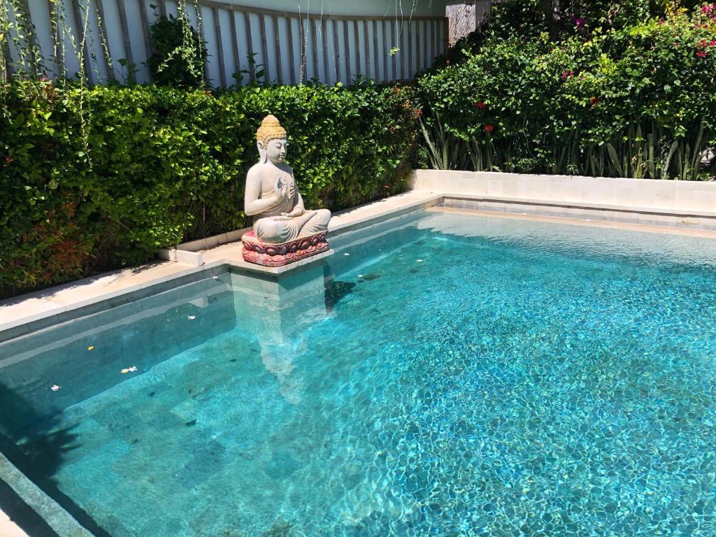 ein kleiner Pool mit einer Statue im Wasser in der Unterkunft Meditasi Bungalows & Villas in Amed