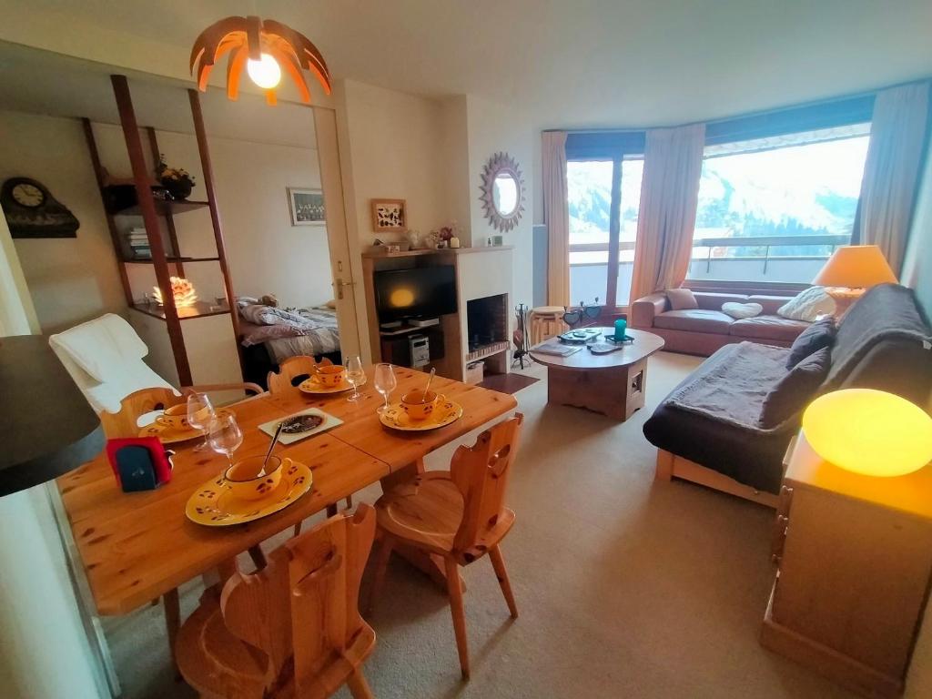 un salon avec une table en bois et un canapé dans l'établissement Avoriaz: Appartement 3 pièces, 6 pers, cheminée, wifi, tout équipé - FR-1-633-69, à Morzine