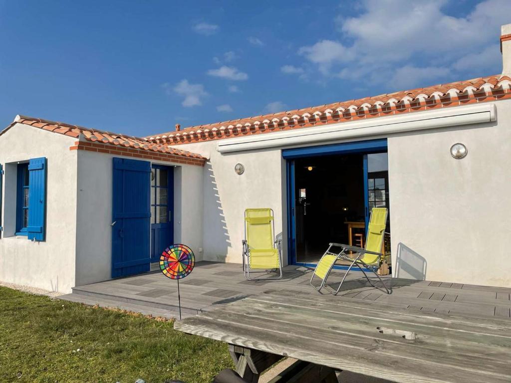 une terrasse avec des chaises, une table et une maison dans l'établissement Charmante maison 4 pers. à 200m plage et port, terrasse, TV, ménage inclus - FR-1-224B-199, à Noirmoutier-en-l'lle
