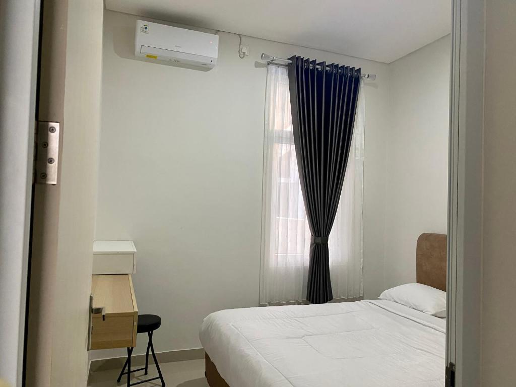 um quarto com uma cama e uma janela em Villa Ku Villa Mu em Semarang