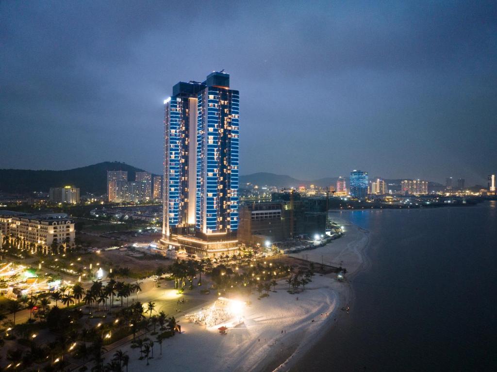 un perfil urbano con un edificio alto por la noche en Alacarte- Rosabella Nguyen en Ha Long