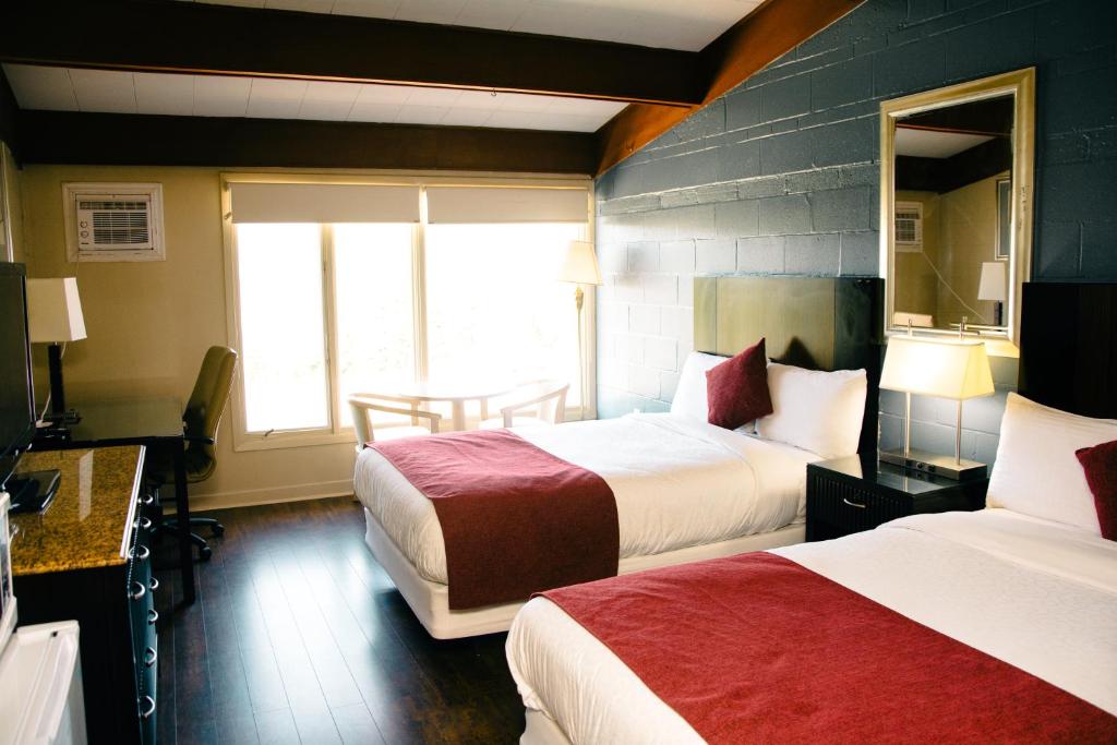 Habitación de hotel con 2 camas y ventana en Travels Inn Victoria County, en Boularderie East