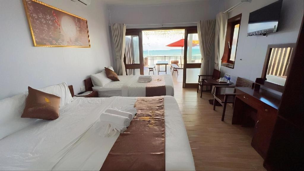 Cette chambre comprend un grand lit et un bureau. dans l'établissement The Poplar Resort Phú Quốc, à Duong Dong