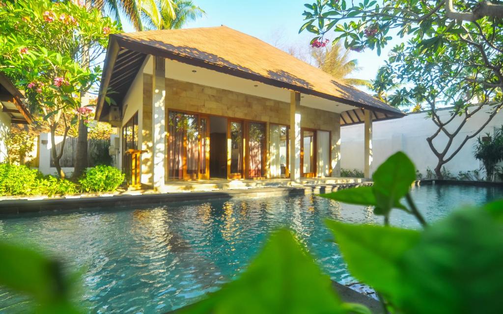 a house with a swimming pool in front of a building at The Haven in Gili Trawangan