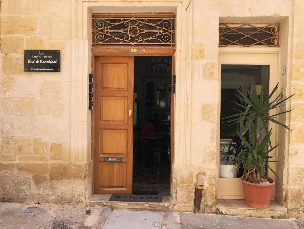 a wooden door in a building with a sign on it at Lee House in Sliema