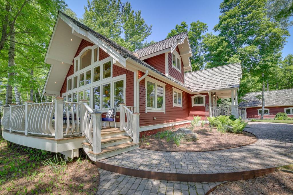ein Haus mit einem roten Haus mit einer Veranda in der Unterkunft Lakefront Michigan Retreat with Private Dock 