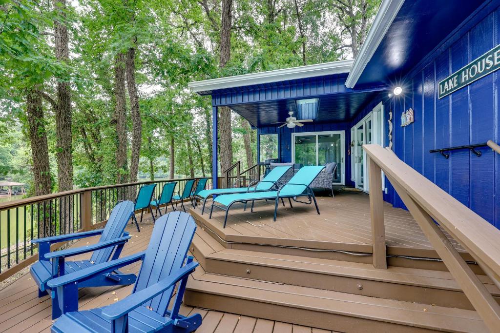 ein blaues Haus mit blauen Stühlen auf einer Terrasse in der Unterkunft Lakefront Hot Springs Vacation Rental with Dock! in Hot Springs Village