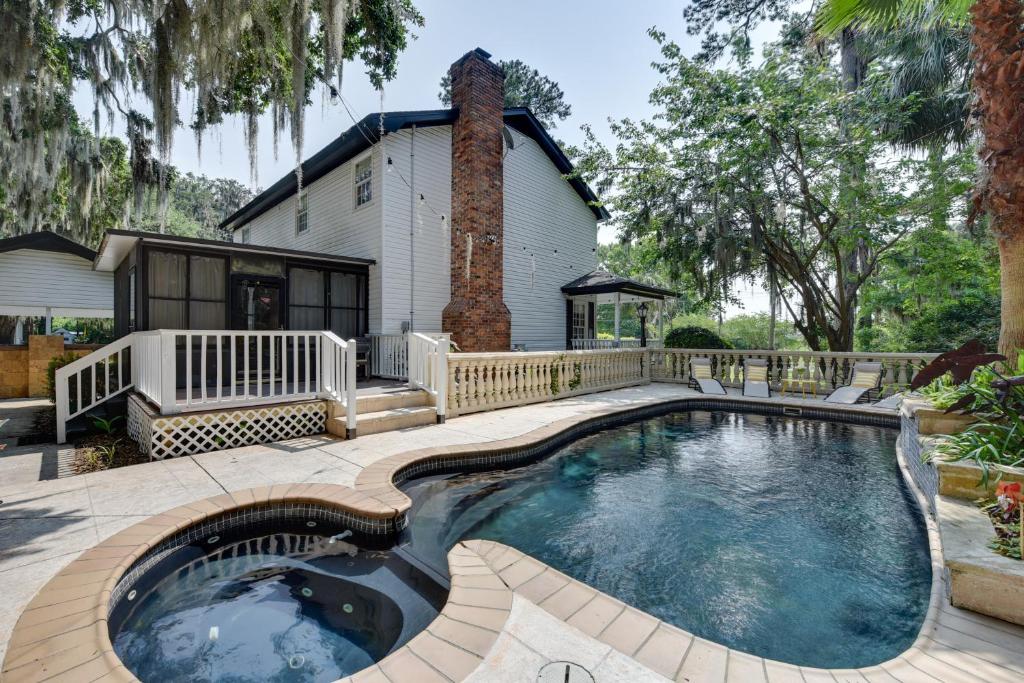 a swimming pool in front of a house at Chic Georgia Getaway with Pool and Deck, Near Beaches! in Savannah