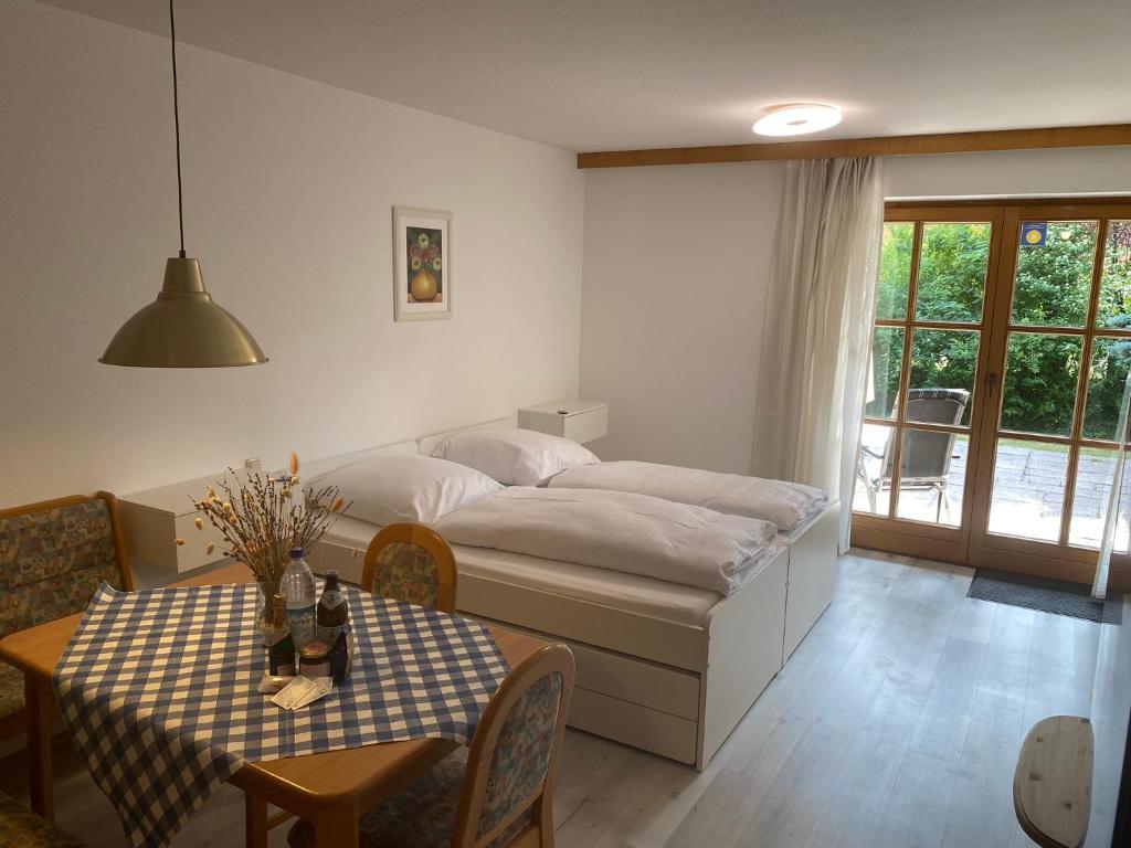 Schlafzimmer mit einem Bett und einem Tisch mit einem sidx sidx sidx in der Unterkunft Haus Rottachbrücke May in Tegernsee
