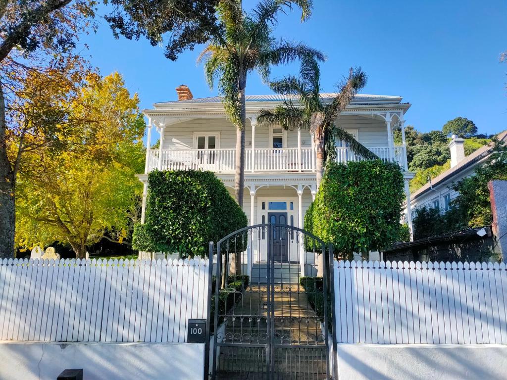 uma cerca branca em frente a uma casa em Andelin Guest House em Auckland