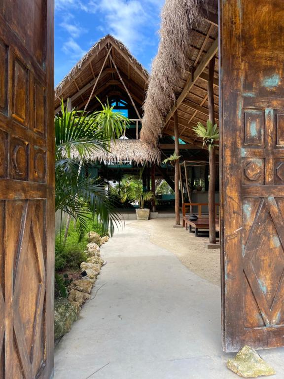 an open door to a resort with a thatch roof at La Bohème Boutique Glamping in General Luna