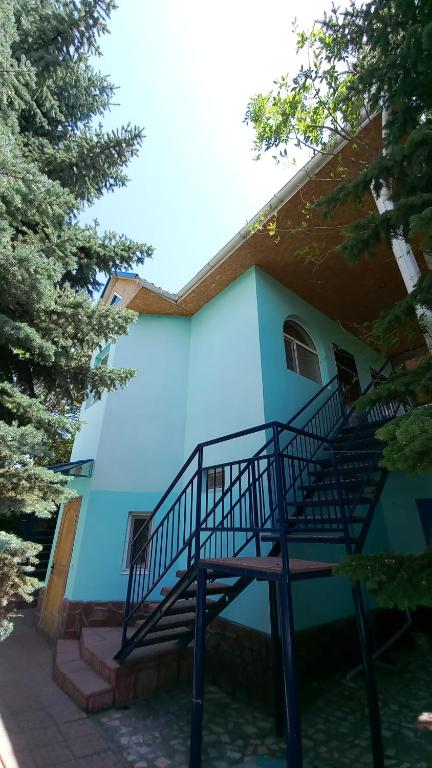 喬爾蓬阿塔的住宿－гостевой дом "Бумеранг KG"，蓝色的建筑,前面有楼梯